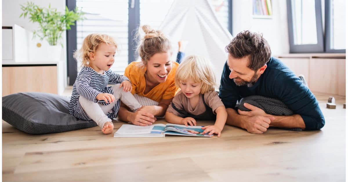 A family gathers on a couch, engaged in reading a book together, creating a warm and joyful atmosphere.