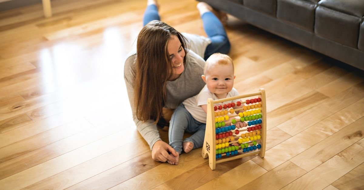 A woman and a baby joyfully playing together with a colorful abacus, fostering early learning and interaction.