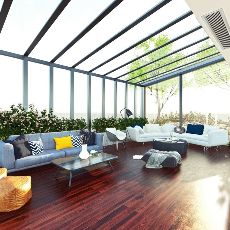 A bright sunroom featuring a large window and an abundance of indoor plants, creating a vibrant and inviting atmosphere