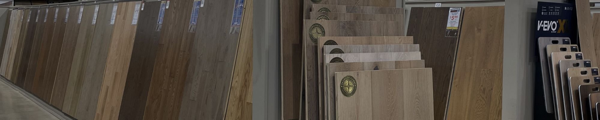 A selection of wood flooring samples displayed in a store, contemplating his choices for home improvement.