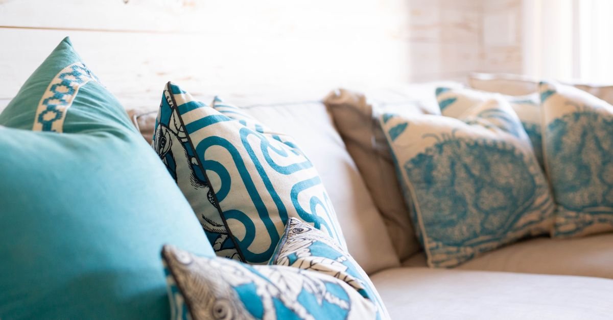 A cozy couch adorned with blue and white pillows, creating a stylish and inviting living space.