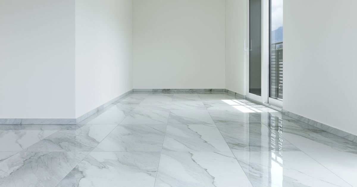 An empty room showcasing a white marble floor and expansive windows, enhancing the sense of openness and light.