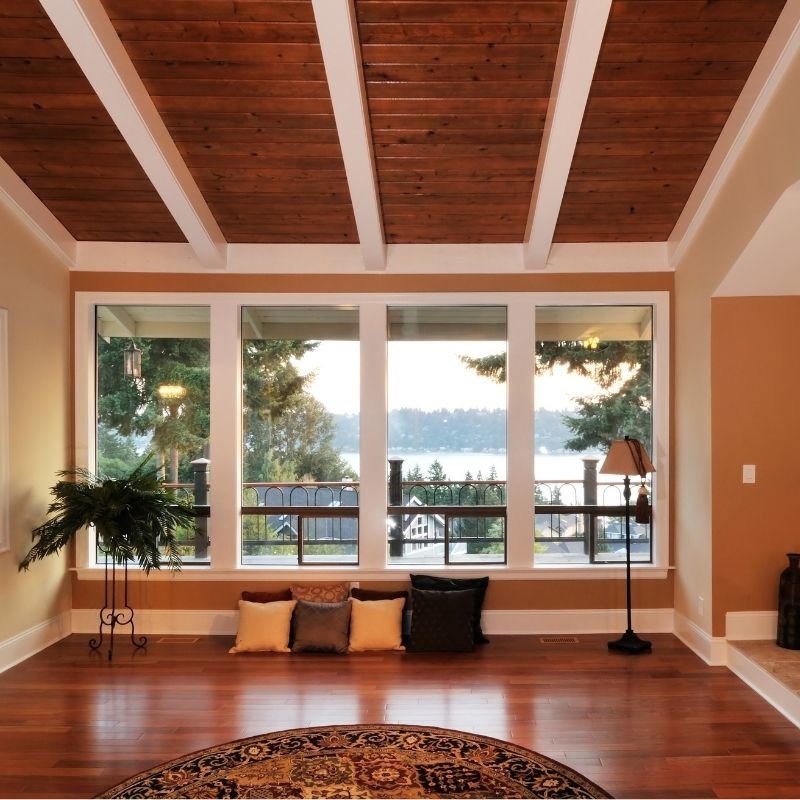 A cozy living room featuring wood floors and large windows allowing natural light to fill the space.