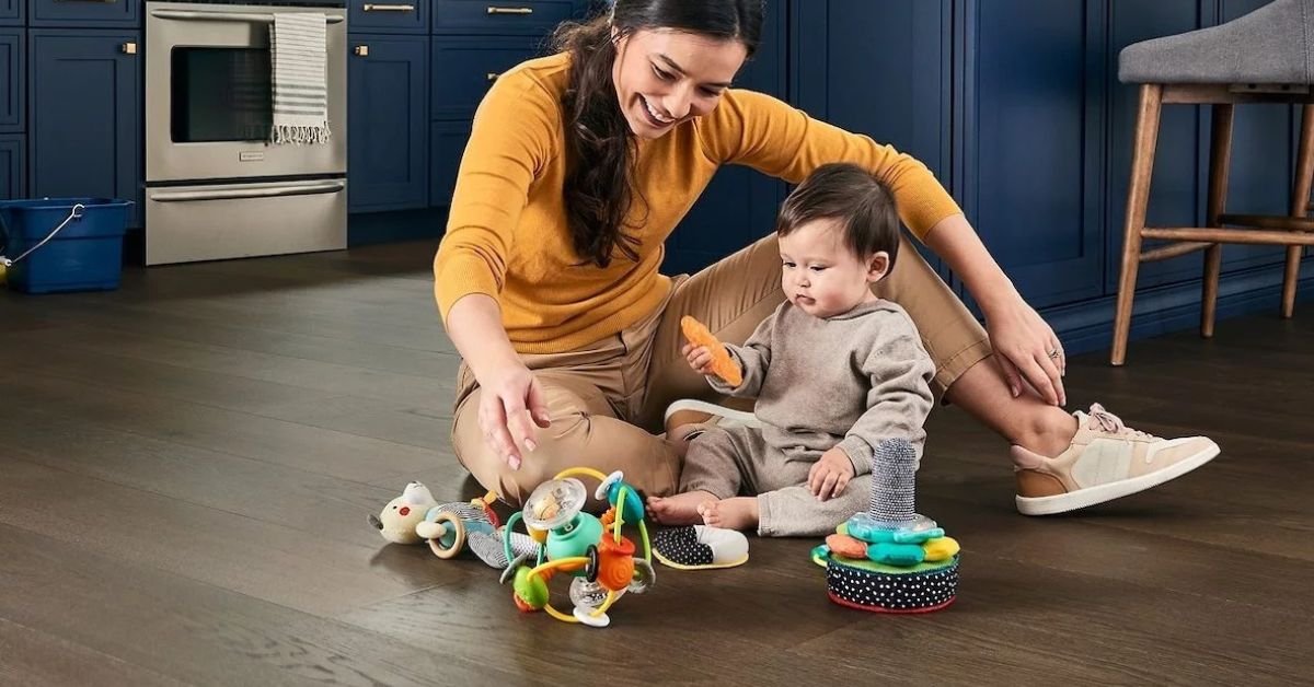 A woman and a baby are happily playing with colorful toys on the floor, engaging in a joyful activity together.