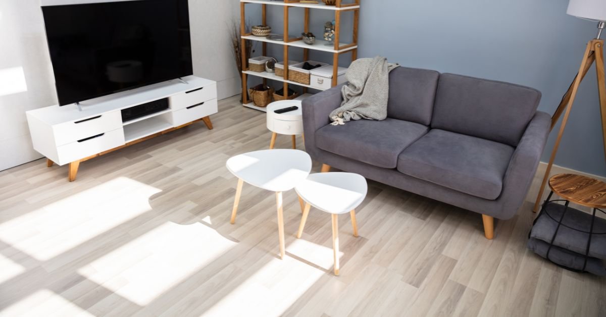 A cozy living room featuring a couch, a television, and shelves filled with books and decorative items.
