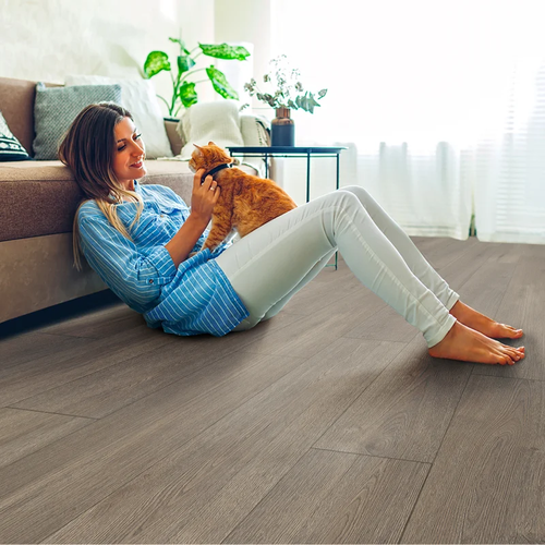 Woman sitting on COREtec floors playing with her dog