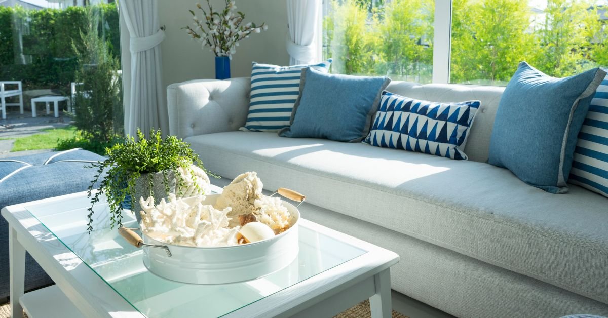 A blue and white living room featuring a couch, coffee table, and decorative pillows arranged for comfort and style.