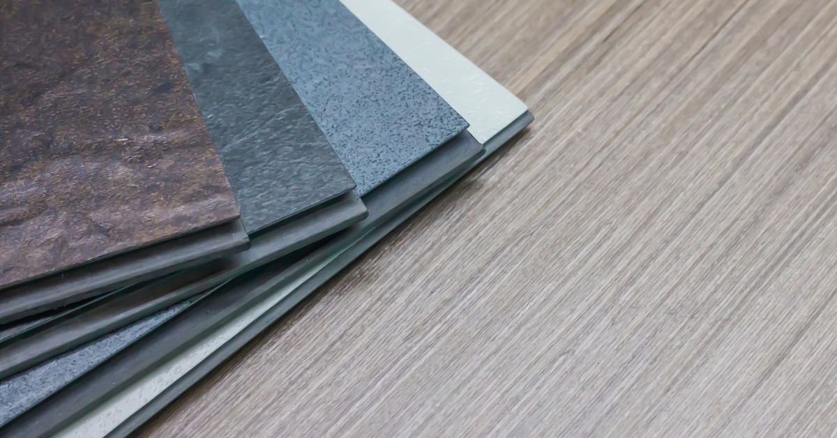 A vibrant stack of assorted tiles placed on a wooden floor, highlighting their diverse colors and textures.