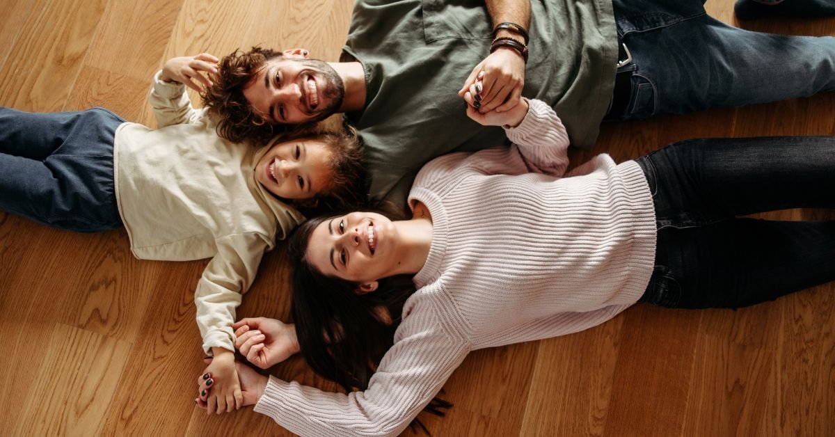 A family is relaxing on the floor in a cozy setting.
