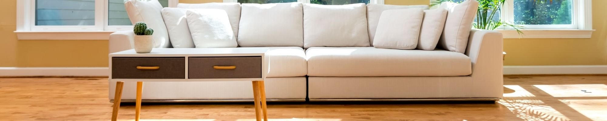 A white couch with a side table in a cozy room setting, showcasing a minimalist interior design.