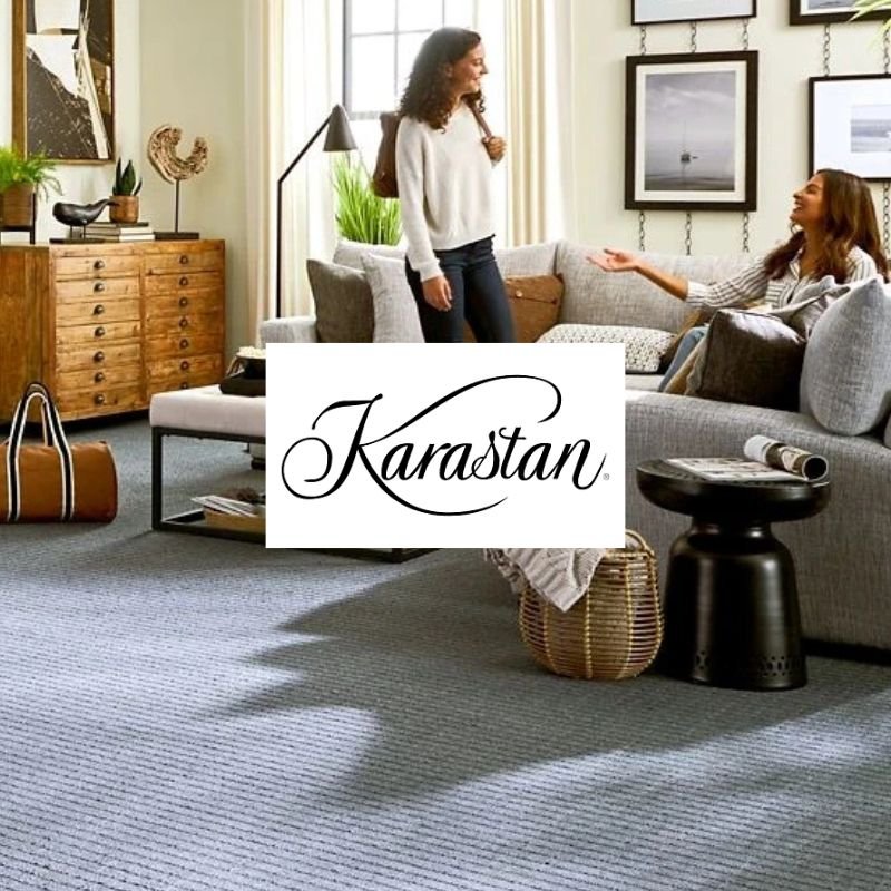 Two women sit together on a couch in a cozy living room, engaged in conversation.